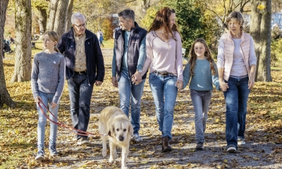 Eine Familie mit drei Generationen spazieren gemeinsam im Wald